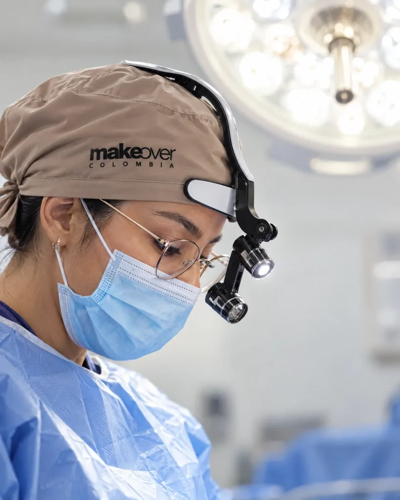 Dra. Katherine Mora de perfil, con gorro de MakeOver Colombia, tapabocas y lupas con luz frontal