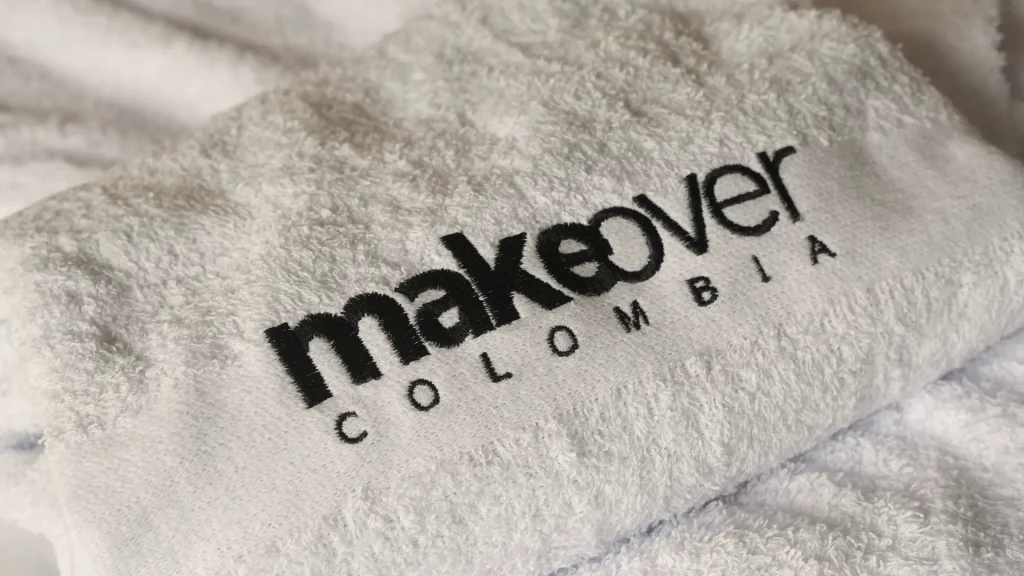 Toalla blanca con el logotipo de MakeOver Colombia bordado